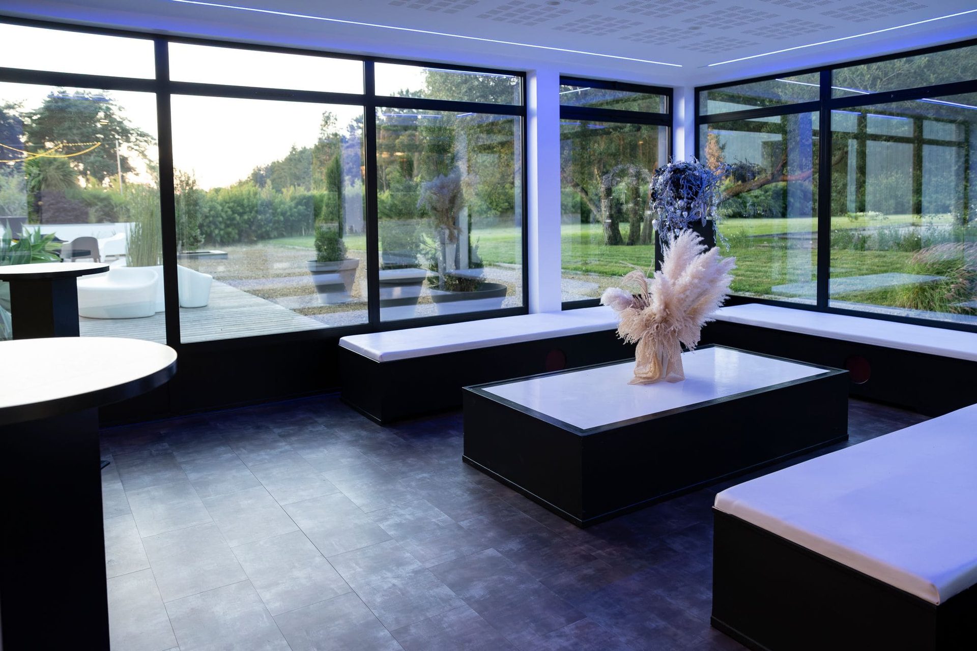 Salle en soirée avec banquettes et grandes baies vitrées