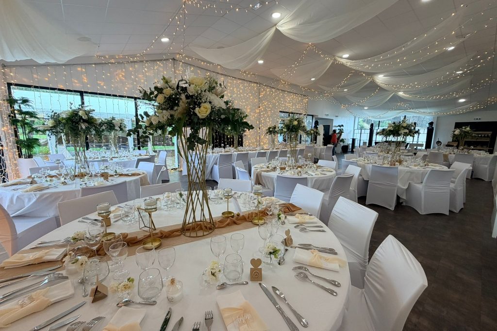 Salle de réception La Parenthèse dressée pour un mariage, plafond drapé et guirlandes lumineuses